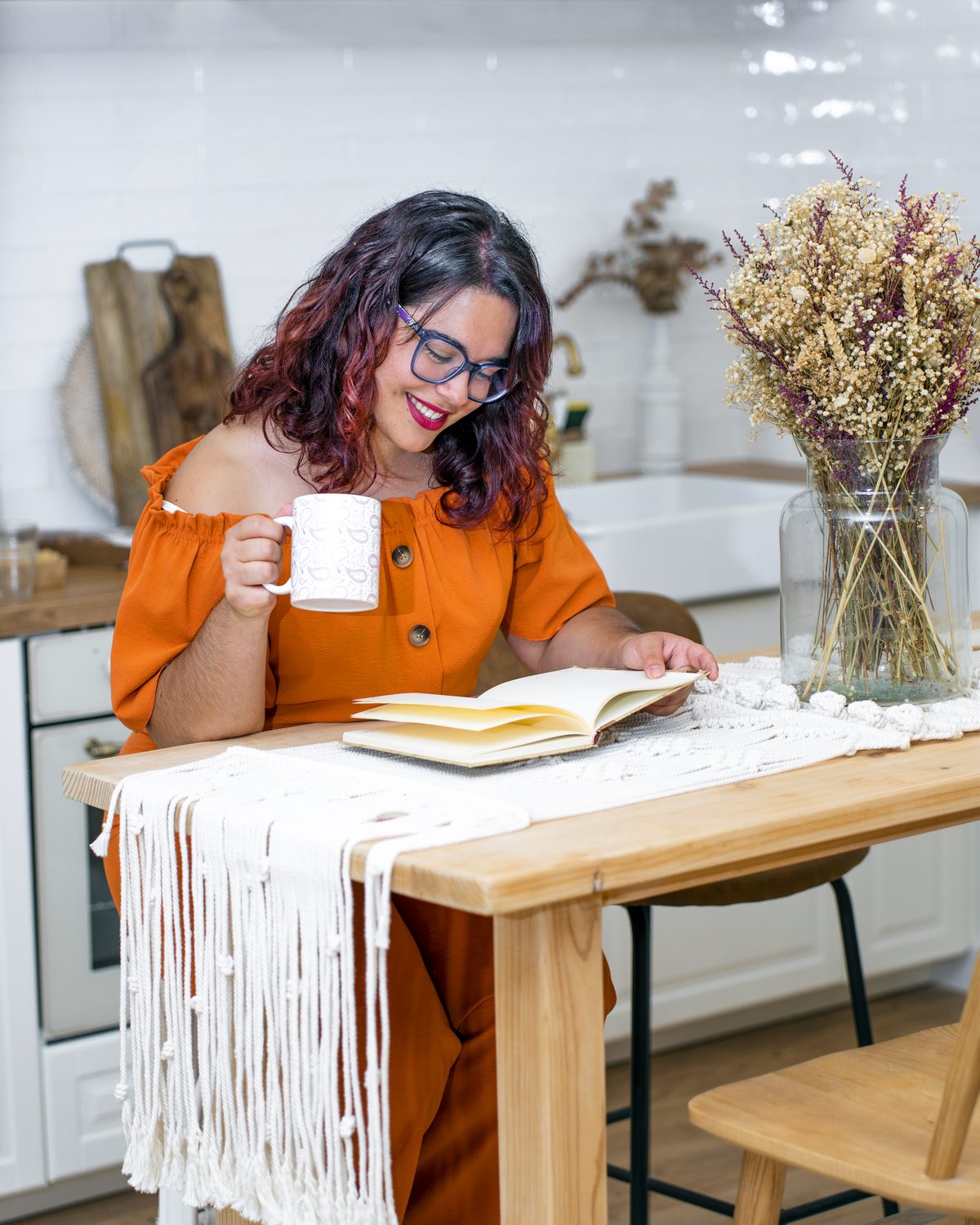 A mom at her kitchen table with coffee and a notebook
